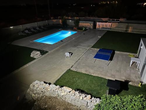 een uitzicht op een zwembad in de nacht bij Villa Perilli - Luxury Stay con piscina privata in Diso