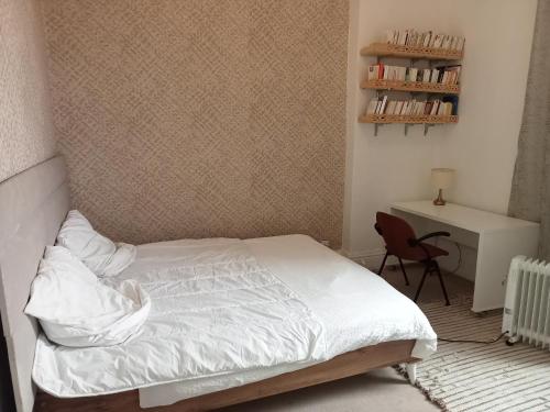 a bedroom with a bed and a desk and a chair at Joli appartement de charme in La Marsa
