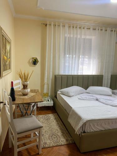 a bedroom with a bed and a table with a chair at Aron’s House in Krujë