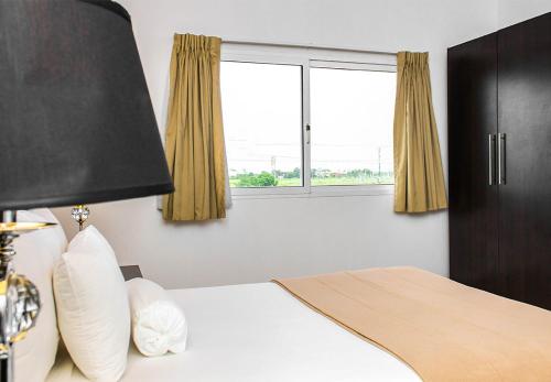 a bedroom with a bed and a window at Hotel Kariña Maturín in Maturín