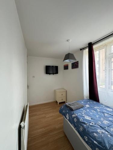 - une chambre avec un lit et une télévision murale dans l'établissement 5 Bedroom House Near Tottenham/Spurs Stadium, à Londres