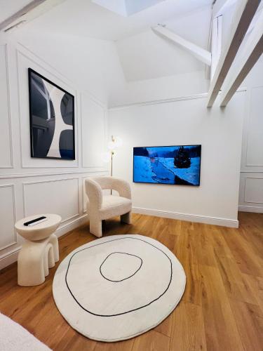 Cette chambre blanche dispose d'une chaise et d'un tapis. dans l'établissement Chez Sandrine, mon appartement élégant + parking, à Strasbourg