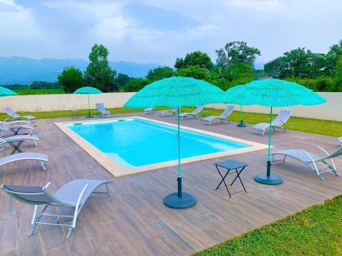- une piscine avec des parasols et des chaises ainsi qu'un bouquet de chaises et de tables dans l'établissement Campo Vecchio Dracena et Piscine, à Ghisonaccia