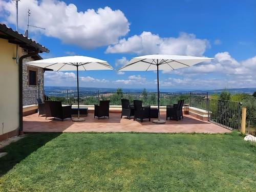 a patio with tables and chairs and umbrellas at La Selvarella in Montecchio