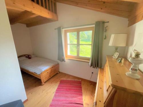 a bedroom with a bed and a window at Alleinstehendes Traumhaus in Poschiavo