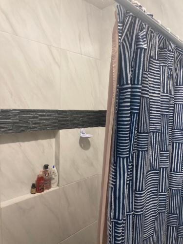 a shower with a blue and white shower curtain in a bathroom at Cancun Oceanfront, Entire Apartment in Cancún