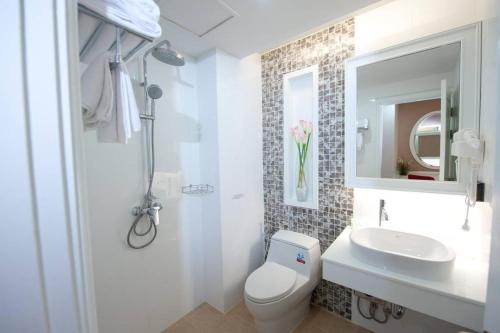 a white bathroom with a toilet and a sink at Sabai Dee Minitel in Dusit