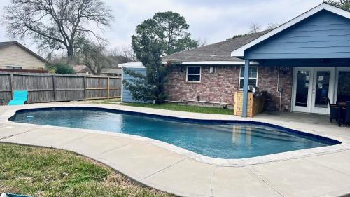 a swimming pool in front of a house at Pool/ Outdoor kitchen/Pool table in Houston