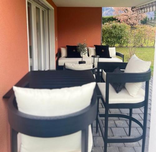 a table and chairs with pillows on a patio at Appartement ALLURE 4 Zimmer Gartenwohnung in Eschen