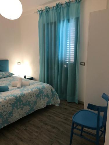 een slaapkamer met een bed, een stoel en een raam bij Brezza marina in Santa Maria Navarrese