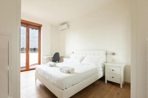 Un dormitorio blanco con una cama blanca y una ventana en Lo Spole Apartment by BarbarHouse, en Milán