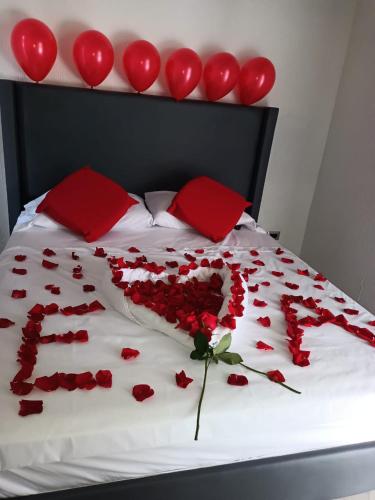 a bed covered in red roses and red pillows at Cabañas LLano Lindo Apiay in Villavicencio