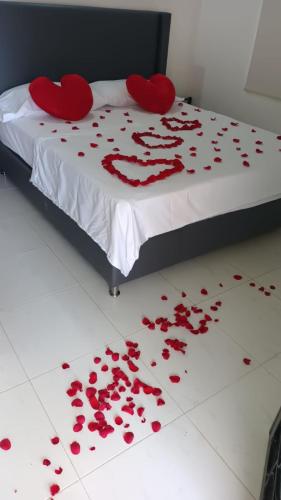 a bed covered in red roses on a white floor at Cabañas LLano Lindo Apiay in Villavicencio