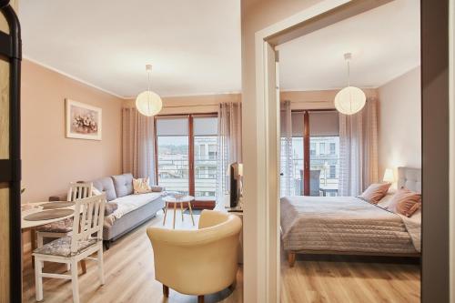 a bedroom with a bed and a living room at Apartamenty Świnoujście - Zacisze Leśne in Świnoujście