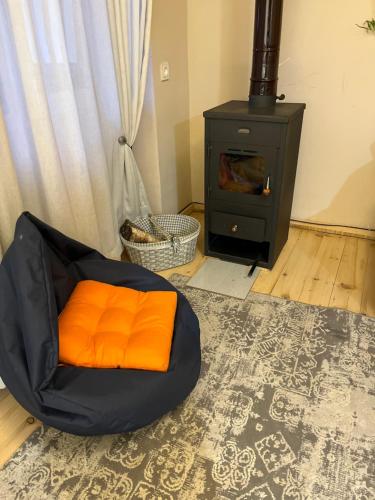 - un oreiller orange dans une chambre avec cuisinière dans l'établissement Apartment Gabliani, à Mestia