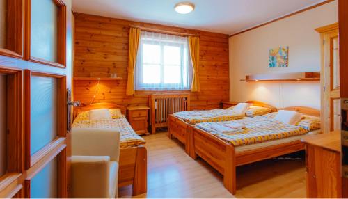 een slaapkamer met 2 bedden en een raam bij Penzión UNA in Liptovský Ján
