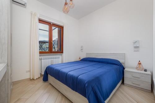 a white bedroom with a bed and a window at Villa Lotos - De Vivo Realty in Massa Lubrense