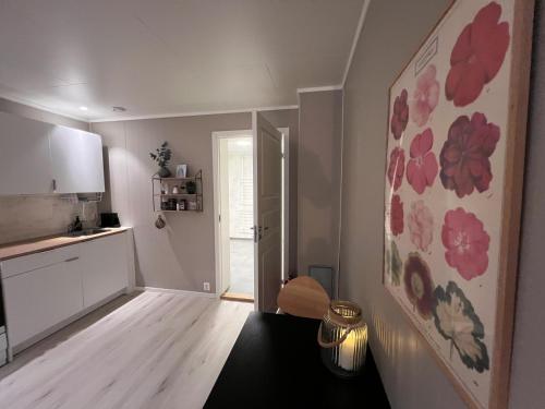 a kitchen with red flowers on the wall at Brand new and private studio apartment! in Bodø