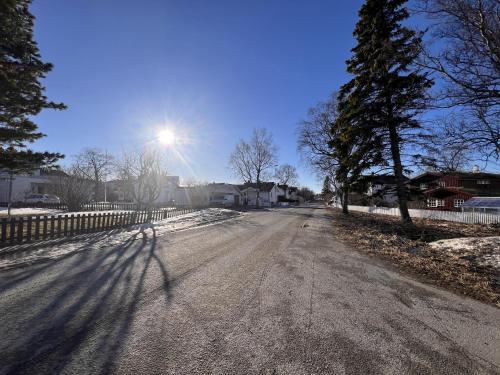 an empty road with the sun in the sky at Charming Studio - Free parking - Close to harbour in Bodø
