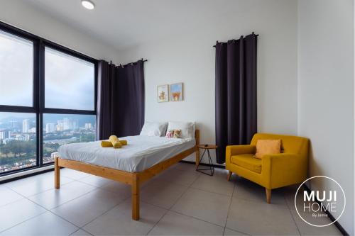 - une chambre avec un lit et une chaise jaune dans l'établissement MUJI X Rilakkuma Seaview 3BR Georgetown with TV Box, à Jelutong