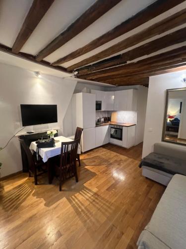 un salon avec une table, des chaises et une télévision dans l'établissement Saint Germain apartment, à Paris