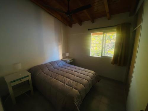 1 dormitorio con cama y ventana en Cerquita de Shopping: depto amoblado urbano en Neuquén