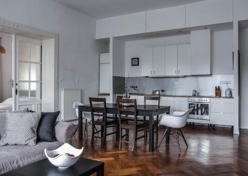 a living room with a table and a kitchen at Stylowy Park Apartment Wawrzyniaka in Wrocław