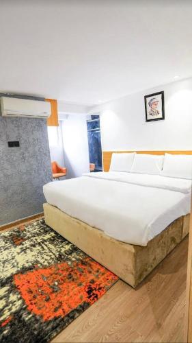 a bedroom with a large white bed with a rug at Predam Realty in Lagos