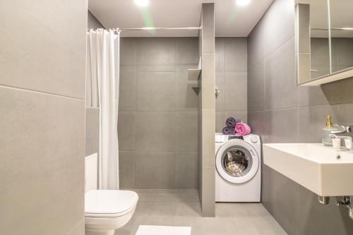 a bathroom with a toilet and a washing machine at Riia 22 Kesklinna Apartment in Tartu