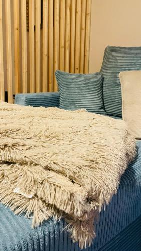 a blanket on a bed next to a blue couch at Villa Belino in Ruhla