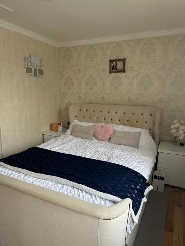 ein Schlafzimmer mit einem großen weißen Bett mit blauer Bettwäsche in der Unterkunft Wellcome to Petru in Nevendon