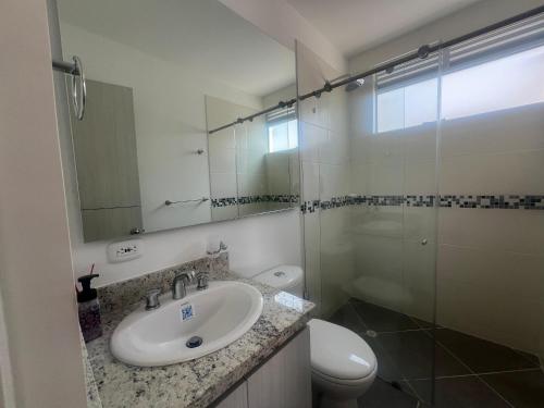 ein Badezimmer mit Waschbecken, Toilette und Spiegel in der Unterkunft Aqualina Orange Girardot, décimo piso in Girardot