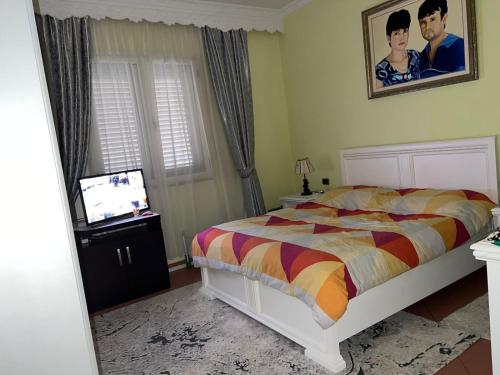 a bedroom with a bed and a television in it at Sunny villa Borakaj Vlora in Vlorë