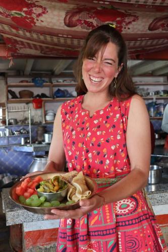 Hasera Organic Farmstay: Farm to Table & Mountain View في دهوليكهيل: امرأة عقد وعاء من الطعام
