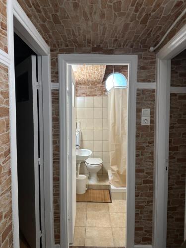 een badkamer met een wit toilet en een wastafel bij The cave in Athene