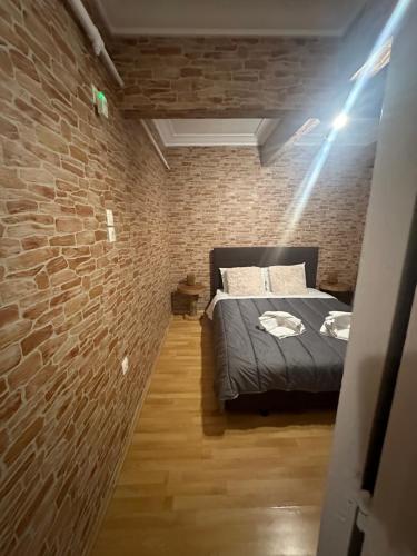 een slaapkamer met een bakstenen muur en een bed bij The cave in Athene