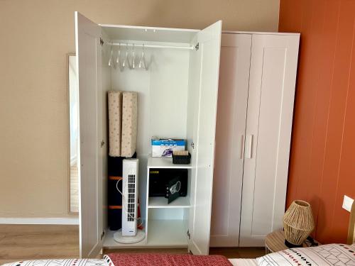 une armoire blanche dans une chambre avec un lit dans l'établissement Douce Agathe - Duo-Groupe, Chaleureux, Tram 200m, Centre 10min, à Strasbourg