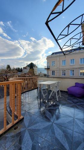 einen Balkon mit einem Tisch und einem Gebäude in der Unterkunft Hotel Antalia in Tbilisi City