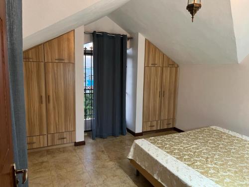 蒙舒瓦西的住宿－La Petite Villa Golf de Mont Choisy，阁楼卧室配有一张床和木制橱柜。