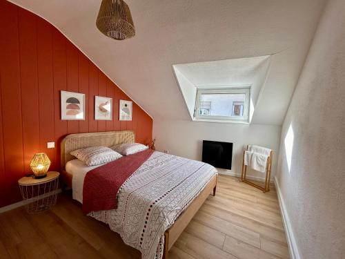 um quarto com uma cama com uma parede vermelha em Douce Agathe - Duo-Groupe, Chaleureux, Tram 200m, Centre 10min em Estrasburgo