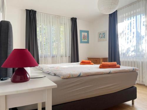 a bedroom with a bed with a red lamp and a desk at Casa Mika in Konstanz