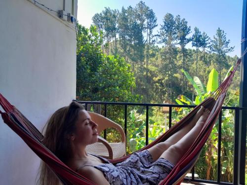 a woman laying in a hammock on a balcony at Silver Dome Guest House in Ella