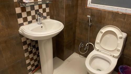 a bathroom with a toilet and a sink at Mums Homestay & Studio Apartments in Kathmandu