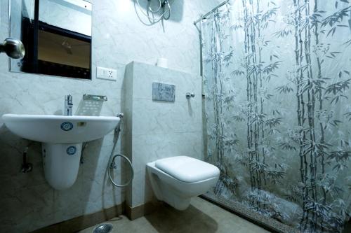 een badkamer met een douche, een toilet en een wastafel bij Hotel Mayank Plaza-Near IGI Airport Terminal-3 in New Delhi