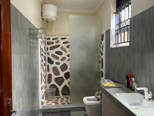 y baño con ducha, aseo y lavamanos. en Ridgeway Victoria, en Wakiso