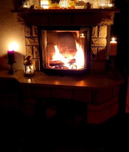a fireplace with a fire in it with two candles at Landhaus Bia in Burig