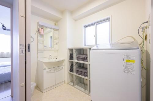 a small bathroom with a sink and a refrigerator at PREMIER suite Shinjuku takadanobaba in Tokyo