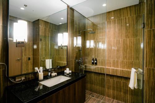 a bathroom with a sink and a large mirror at Hotel A & A Quezon City powered by Cocotel in Manila