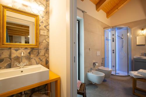 W łazience znajduje się umywalka, toaleta i lustro. w obiekcie d'ARTEmisia Chambres d'hôtes w mieście Pont-Saint-Martin