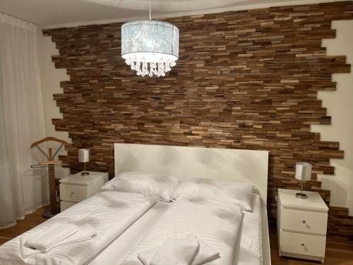 a bedroom with a large white bed with a brick wall at Molo Lipno Apartment C301 Lipno Home in Lipno nad Vltavou
